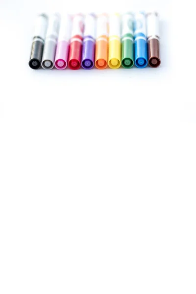 Vertical shot of different color markers on a white surface - great for writing text or background — Stock Photo, Image