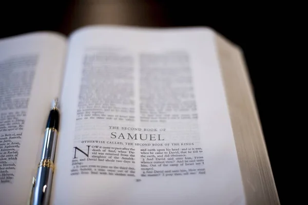 Primer plano de una pluma estilográfica en medio de una biblia abierta — Foto de Stock