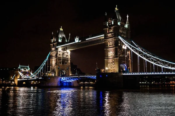 Hermosa toma del iluminado Tower Bridge en Londres por la noche con un fondo totalmente negro — Foto de Stock