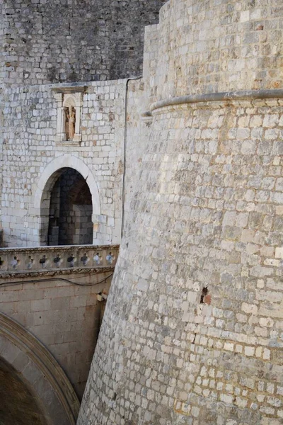 Tiro vertical de um castelo de pedra partes com paredes brancas e um arco - arquitetura histórica — Fotografia de Stock