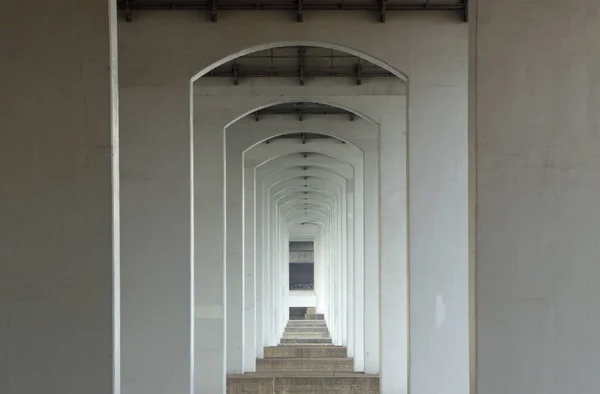 Corredor largo con paredes blancas en forma de arco en un edificio antiguo —  Fotos de Stock