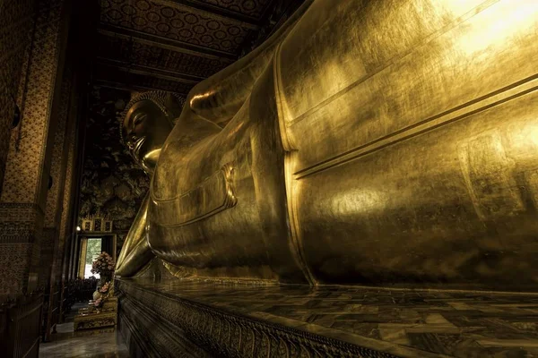 Statue de Bouddha inclinable dorée à l'intérieur d'un temple avec de beaux motifs — Photo