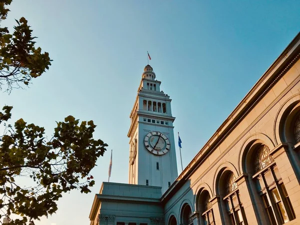 Low angle shot of Ferry Building in San Francisco near green trees under the beautiful sky — Stock Photo, Image