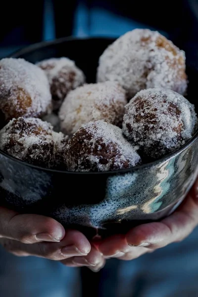 Verticaal schot van palmen met een kom gevuld met rum ballen op wazige achtergrond — Stockfoto