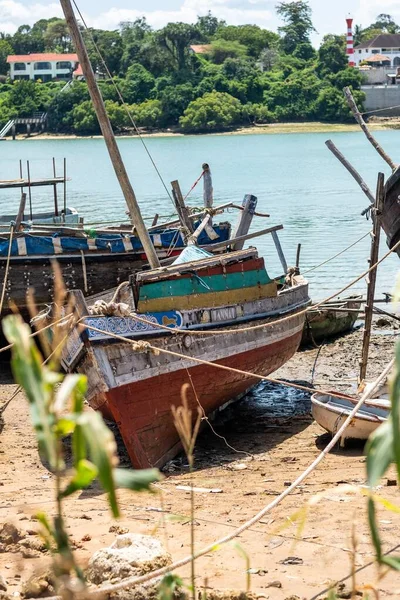 Tiro vertical de barcos enferrujados na margem do rio capturados em Mombaça, Quênia — Fotografia de Stock
