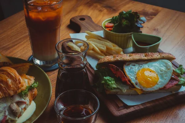 Поднос с вкусной едой, картошкой фри, салатом и стаканом кофе — стоковое фото