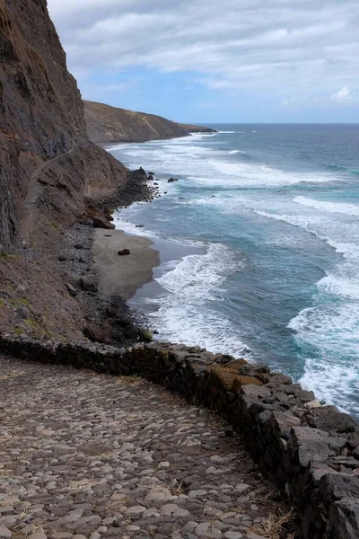 Tiro de ângulo alto de uma formação de rocha na praia abaixo do céu claro — Fotografia de Stock