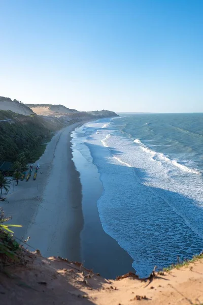 Vertikal bild av det vackra vågiga havet kommer till stranden fångas i Pipa, Brasilien — Stockfoto