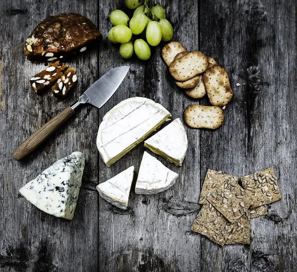 Duże ujęcie kąta pysznego sera brie na drewnianym tarasie - idealne na blogu kulinarnym — Zdjęcie stockowe