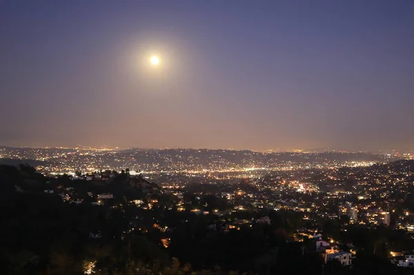 Fotografia aérea de uma bela paisagem urbana com um monte de edifícios iluminados à noite — Fotografia de Stock