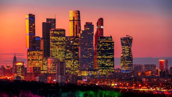 Tiro de tirar o fôlego de uma megapolis com arranha-céus iluminados de tarde — Fotografia de Stock