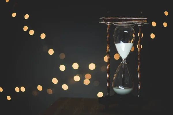 Detailní záběr časovače pískového skla s rozmazanými světly v pozadí — Stock fotografie