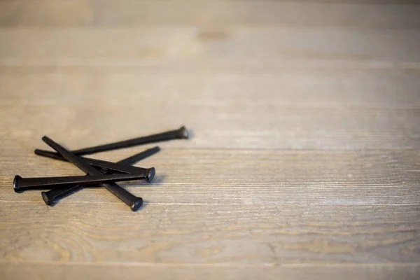 Primer plano de clavos sobre una superficie de madera con un fondo borroso — Foto de Stock