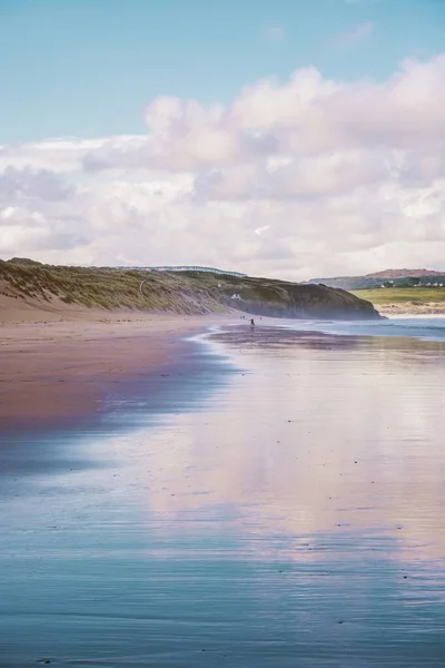 Tiro vertical do reflexo do céu no mar pela praia capturada na Cornualha, Inglaterra — Fotografia de Stock