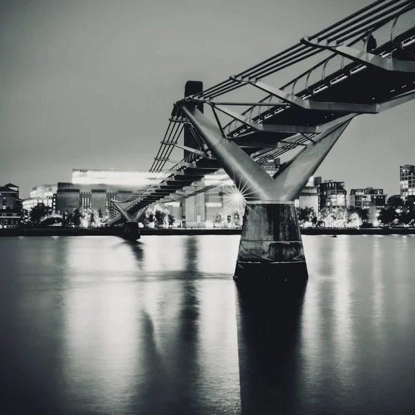 Grayscale tembakan sudut rendah dari London Millenium Bridge di Inggris — Stok Foto