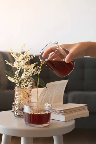 Colpo verticale di una persona che versa il tè nella tazza in un accogliente soggiorno — Foto Stock