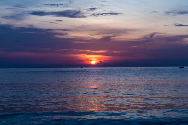 Beautiful shot of the setting sun in the colorful sky above the calm ocean in — Stock Photo, Image