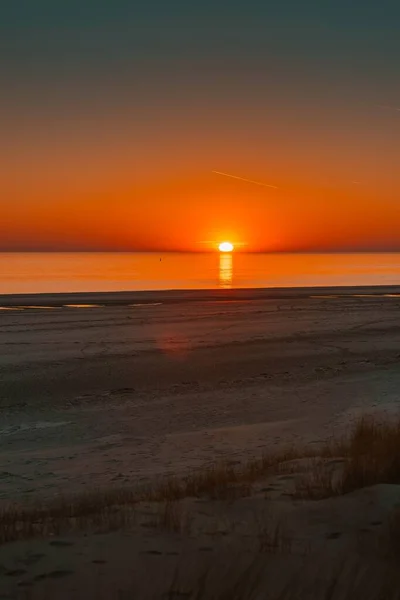 Vertikale Aufnahme der Spiegelung des Sonnenuntergangs im Meer, aufgenommen in Westschouwen, Niederlande — Stockfoto