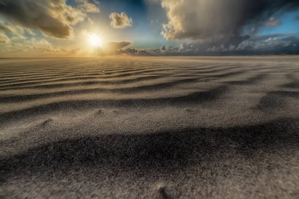 Piękne ujęcie słońca wschodzącego nad piaszczystą plażą nad brzegiem morza — Zdjęcie stockowe