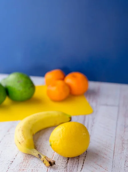 Függőleges közelkép néhány gyümölcsről egy fa asztalon — Stock Fotó