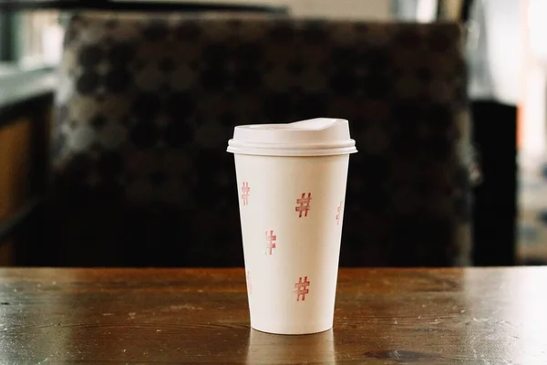 Крупный план чашки белого кофе с хештегами на столе - # coffee — стоковое фото