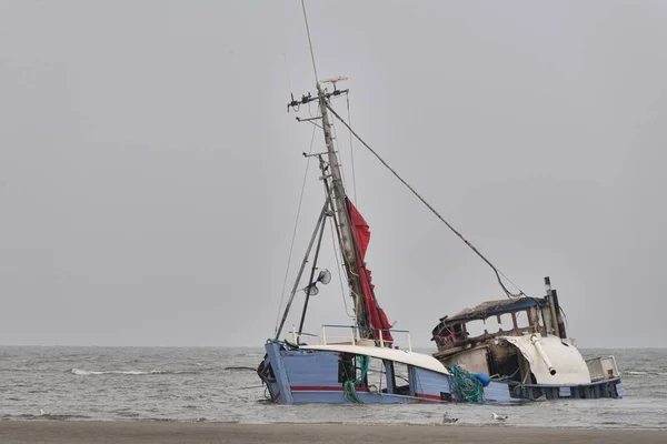 Hundiendo un barco abandonado en la orilla del mar bajo el cielo despejado — Foto de Stock