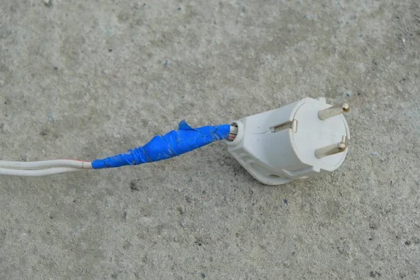 Tiro de ângulo alto de um fio danificado fixado com uma fita isolante azul — Fotografia de Stock