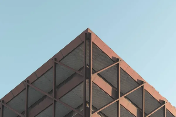 Baixo ângulo tiro de um belo edifício moderno no meio da cidade sob o céu limpo — Fotografia de Stock