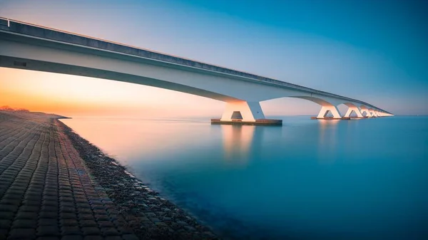 Vista deslumbrante de uma ponte sobre um rio pacífico capturado em Zeelandbridge, Países Baixos — Fotografia de Stock