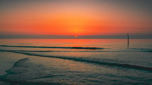 Beautiful view of the sunset over a peaceful ocean captured in Domburg, Netherlands — Stock Photo, Image