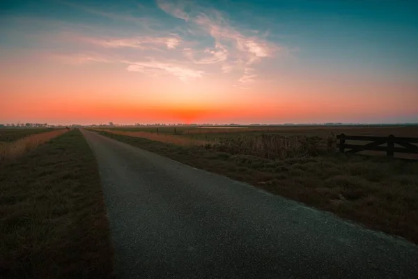 Estrada entre os campos sob o belo pôr do sol no céu em Middleburg, Países Baixos — Fotografia de Stock