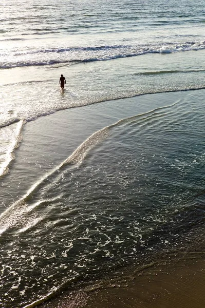 Plan vertical à angle élevé d'un mâle debout dans l'océan le matin — Photo