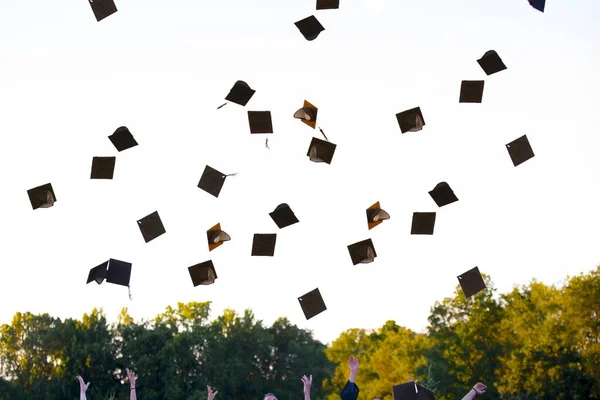 Beau plan de diplômés avec leurs chapeaux en plein air — Photo