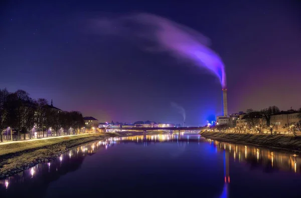 Прекрасний знімок барвистого диму, що поширюється в місті відображається в річці вночі — стокове фото