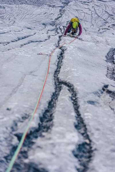 Tiro vertical de uma pessoa escalando uma rocha nos Alpes na Áustria superando o conceito de desafios — Fotografia de Stock