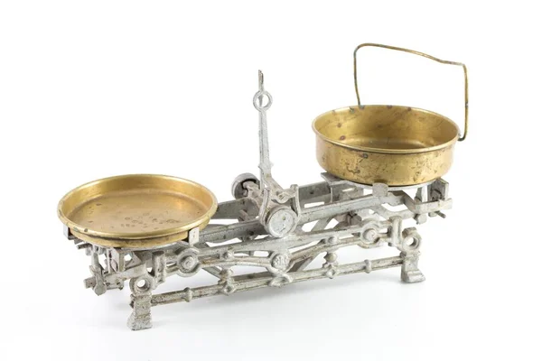 High angle shot of an old silver scale with golden containers isolated on a white background — ストック写真