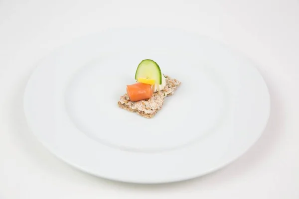 Delicioso plato con pescado y pepino en un plato blanco aislado sobre fondo blanco — Foto de Stock