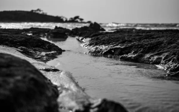 Grayscale opname van veel rotsformaties in de zee - ideaal voor een koele achtergrond — Stockfoto