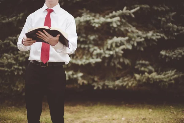 Primer plano de un hombre bien vestido leyendo la Biblia con un fondo borroso — Foto de Stock
