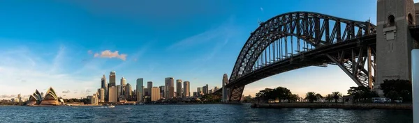 Panoramische opname van Sydney Harbour Bridge in Australië met hoge wolkenkrabbers op de achtergrond — Stockfoto