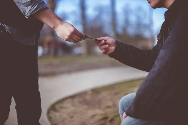 Nahaufnahme eines Mannes, der Broschüren an einen anderen Mann mit verschwommenem Hintergrund verteilt — Stockfoto