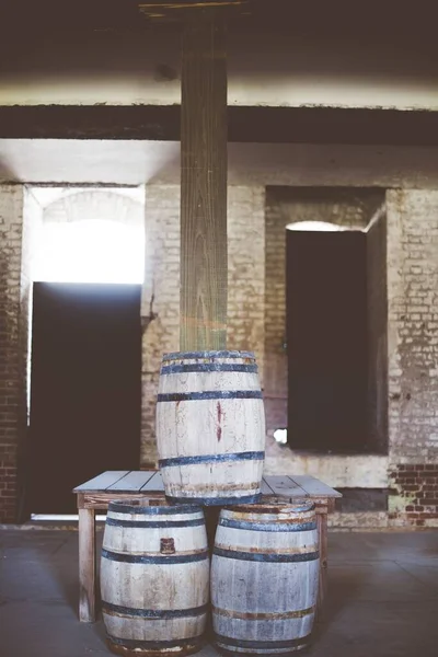 Vertical shot of wooden barrels on top of each other with a blurred background — Stock Photo, Image