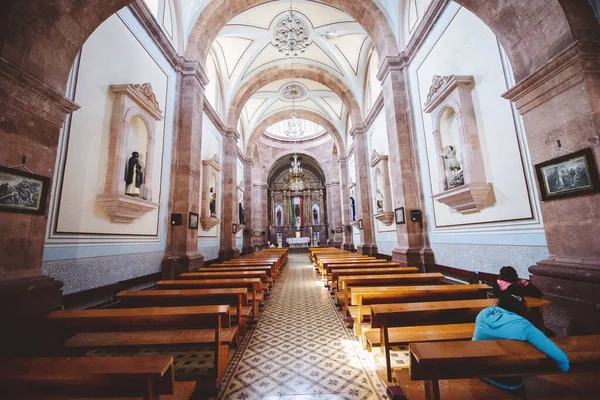 Vnitřní záběr kostela s lidmi sedícími na dřevěných lavicích — Stock fotografie