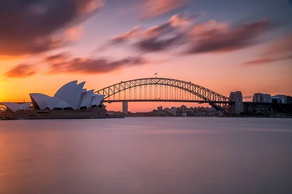 Piękne ujęcie Sydney Harbor Bridge z jasnoróżowym i niebieskim niebem w tle o zachodzie słońca — Zdjęcie stockowe