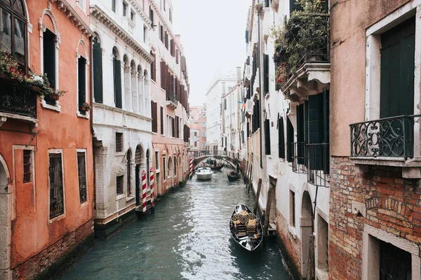 Высокоугольный снимок красивого канала в Венеции с гондолами между двумя зданиями — стоковое фото