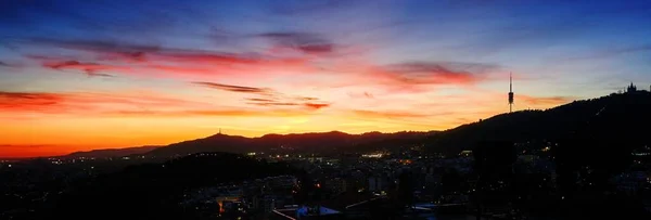 Panorama de una hermosa ciudad bajo el atardecer en un cielo colorido —  Fotos de Stock