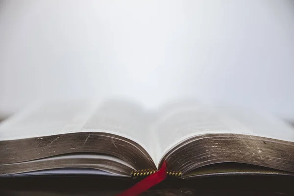 Primo piano della Bibbia con pagine dorate e sfondo sfocato — Foto Stock