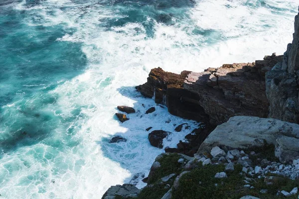 High angle shot of a rock formation near the body of turquoise water — Stok fotoğraf