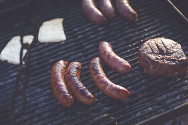 Primo piano di alcuni deliziosi hot dog e manzo cucinato su un barbecue — Foto Stock