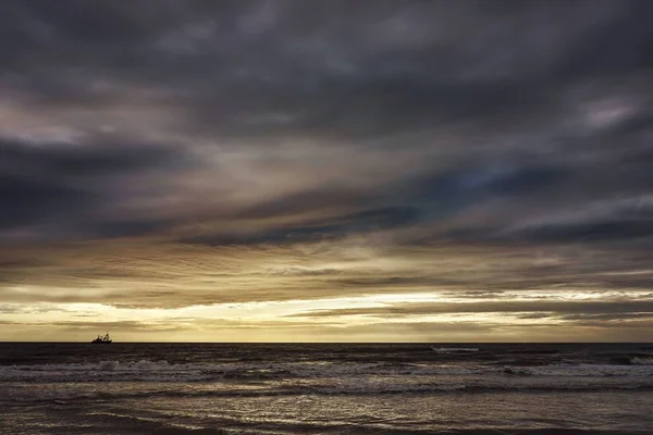 Gün batımında okyanustaki bulutlu gökyüzünün yansımasının nefes kesici görüntüsü. — Stok fotoğraf
